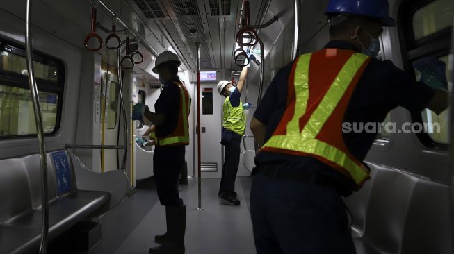 Petugas membersihkan bagian dalam pada rangkaian kereta Light Rapid Transit (LRT) di Depo LRT Jakarta, Kelapa Gading, Jakarta Timur, Jumat (6/3). [Suara.com/Angga Budhiyanto]