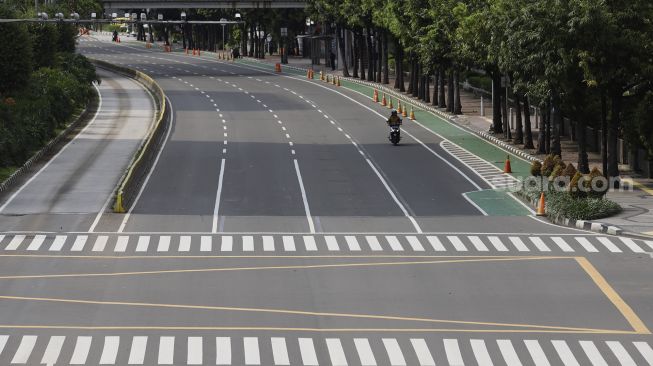 Pengendara sepeda motor melintas di Jalan M.H. Thamrin, Jakarta, Rabu (1/4). [Suara.com/Angga Budhiyanto]