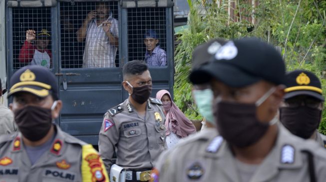 Polisi mengamankan warga yang diduga provokator saat melakukan aksi menutup jalan menuju ke pemakaman Macanda di Kecamatan Somba Opu, Kabupaten Gowa, Sulawesi Selatan, Kamis (2/4).[ANTARA FOTO/Abriawan Abhe]