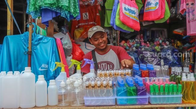 Pedagang merapihkan  wadah botol hand sinitizer di Pasar Tradisional Jatinegara, Jakarta Timur, Sabtu (4/4).[Suara.com/Alfian Winanto]
