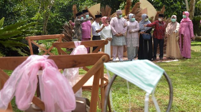 Tamu mengenakan masker saat menghadiri akad nikah pasangan suami-isteri Bayu Amde Winata dan Mike Agnesia yang berlangsung saat tanggap darurat COVID-19 di Kota Pekanbaru, Riau, Sabtu (4/4). [ANTARA FOTO/FB Anggoro]