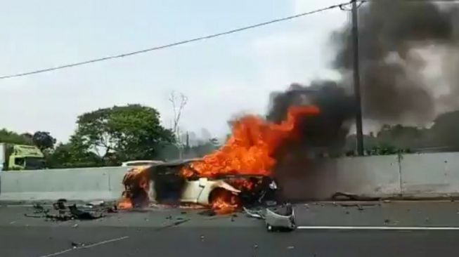 Satu unit mobil terbakar di KM 13 Cibubur lintasan Tol Jagorawi arah Jakarta, Sabtu (4/4/2020). Satu pengemudi dilaporkan tewas dan satu penumpang luka berat dalam kejadian itu. [dok.Polda Metro Jaya]