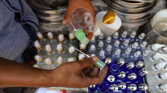 Pedagang menunjukkan botol yang digunakan untuk menampung handsinitizer di Pasar Tradisional Jatinegara, Jakarta Timur, Sabtu (4/4). [Suara.com/Alfian Winanto]
