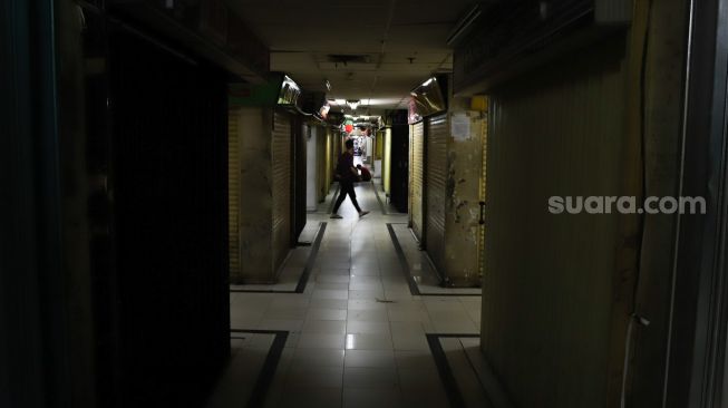 Pengunjung melintas di pertokoan tutup di Pasar Jatinegara, Jakarta Timur, Sabtu (4/4). [Suara.com/Alfian Winanto]