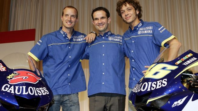 Davide Brivio, saat masih menjabat manajer tim Yamaha, diapit kedua pebalapnya Colin Edwards (kiri) dan Valentino Rossi dalam sebuah acara di Tokyo, Jepang, Senin (7/3/2005). [AFP/Toshifumi Kitamura]