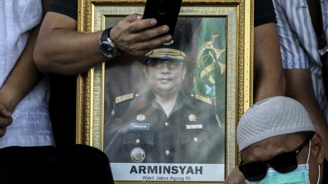 Kerabat memegang foto Almarhum Wakil Jaksa Agung Arminsyah saat pemakaman di Tempat Pemakaman Umum (TPU) Pedongkelan, Jakarta, Minggu (5/4). [ANTARA FOTO/Rivan Awal Lingga]