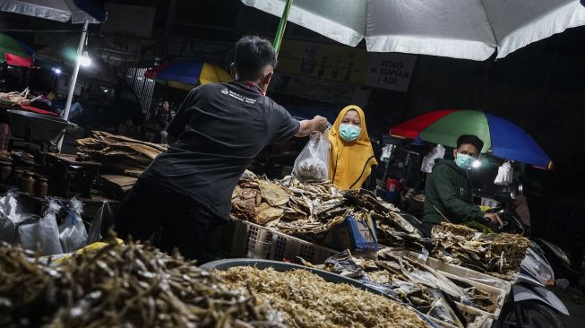 Pedagang melayani pembeli di pasar tumpah Palangkaraya, Kalimantan Tengah, Sabtu (4/4/2020) malam. [ANTARA FOTO/Makna Zaezar]