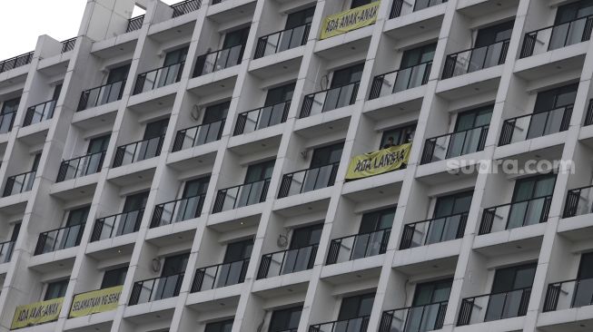 Penghuni apartemen Nine Residence memasang spanduk penolakan rumah sakit darurat virus Corona (COVID-19) di Lippo Plaza Mampang, Jakarta, Minggu (5/4). [Suara.com/Angga Budhiyanto]