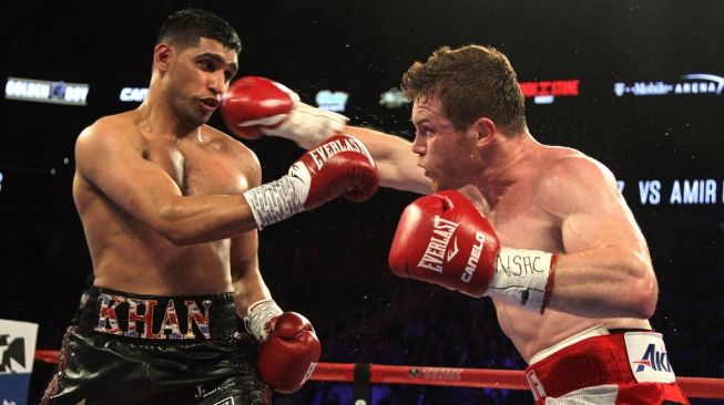 Petinju Meksiko Saul Alvarez (kanan) melayangkan pukulan ke wajah Amir Khan dari Inggris dalam duel kejuaraan tinju dunia di Las Vegas, Amerika Serikat, Sabtu (7/5/2016). [AFP/John Gurzinski]