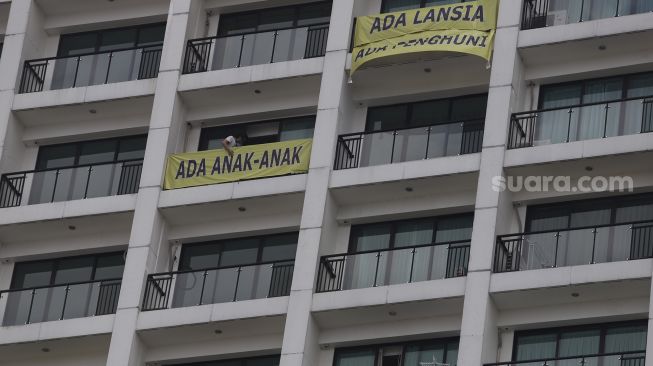 Penghuni apartemen Nine Residence memasang spanduk penolakan rumah sakit darurat virus Corona (COVID-19) di Lippo Plaza Mampang, Jakarta, Minggu (5/4). [Suara.com/Angga Budhiyanto]