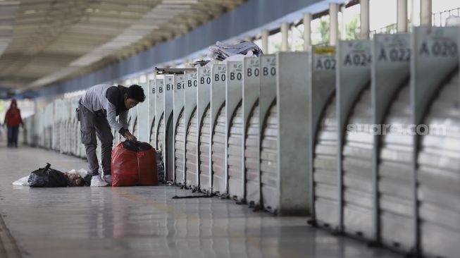 Pedagang merapikan dagangannya di Skybridge atau Jembatan Penyeberangan Multiguna (JPM) Tanah Abang di Jakarta, Senin (6/4). [Suara.com/Angga Budhiyanto]