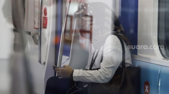 
Penumpang memakia masker saat berada di dalam kereta Moda Raya Terpadu (MRT) di Stasiun MRT Lebak Bulus, Jakarta Selatan, Senin (6/4). [Suara.com/Angga Budhiyanto]