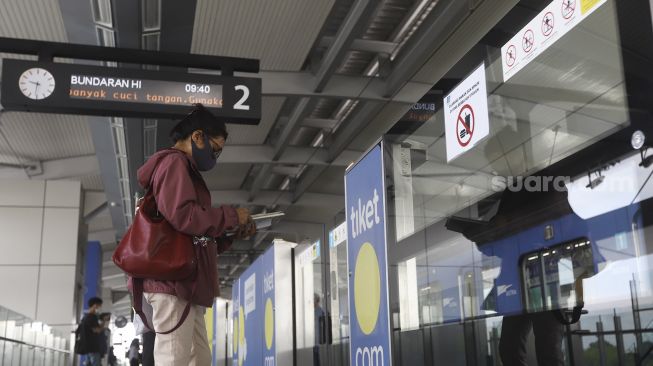 Calon penumpang memakai masker saat menunggu kereta Moda Raya Terpadu (MRT) di Stasiun MRT Lebak Bulus, Jakarta Selatan, Senin (6/4).  [Suara.com/Angga Budhiyanto]