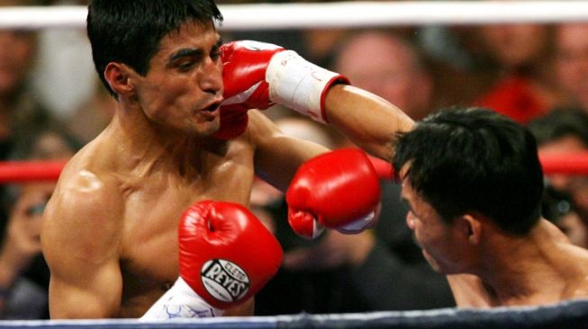 Petinju Filipina Manny Pacquiao (kanan) berduel melawan Erik Morales dari Meksiko dalam kejuaraan tinju dunia di Las Vegas, Sabtu (18/11/2006). [AFP/Gabriel Bouys]