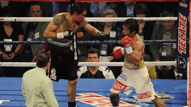 Petinju Filipina Manny Pacquiao (kanan) berduel melawan Antonio Margarito dari Meksiko dalam kejuaraan tinju dunia di Cowboys Stadium, Sabtu (13/11/2010). [AFP/Robyn Beck]