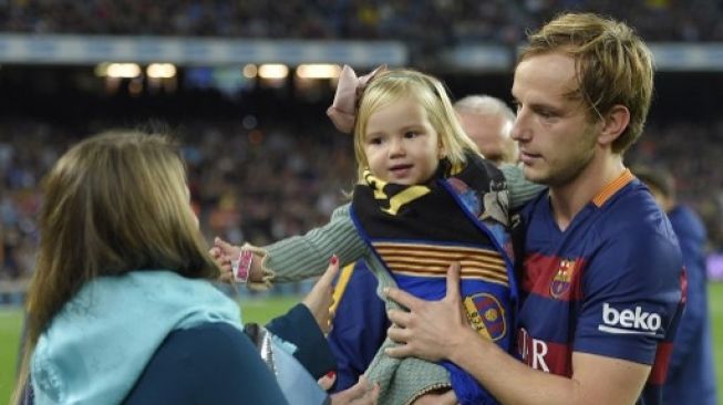 Pemain Barcelona Ivan Rakitic bersama anak dan istrinya usai Barcelona sukses meraih gelar juara La Liga. [AFP]