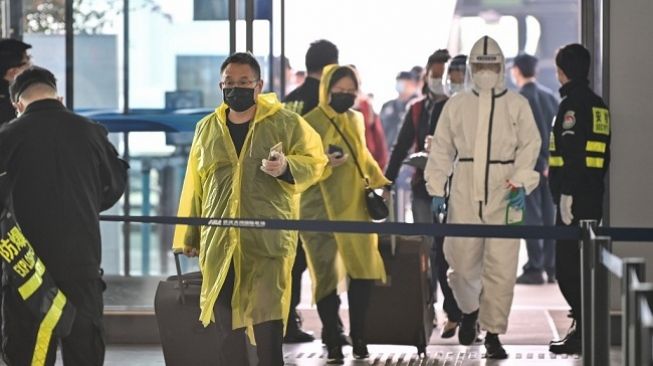 Para calon penumpang beramai-ramai keluar dari Kota Wuhan di Bandara Tianhe setelah status lockdown dicabut.(Foto: AFP)