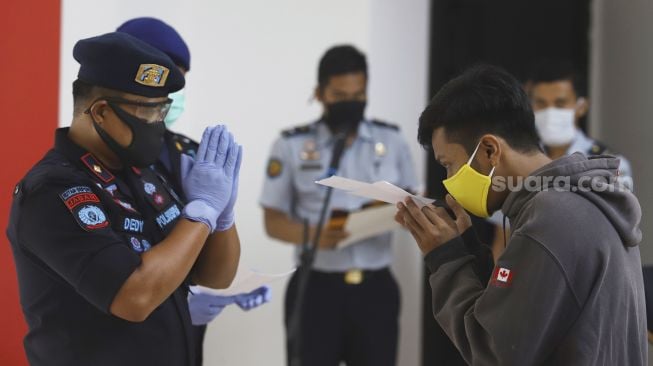 Narapidana mendapatkan surat kesehatan saat mengikuti upacara pelepasan di Rumah Tahanan Negara (Rutan) Kelas I Depok, Jawa Barat, Kamis (9/4). [Suara.com/Angga Budhiyanto]