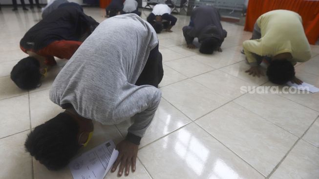 Narapidana melakukan sujud syukur saat mengikuti upacara pelepasan di Rumah Tahanan Negara (Rutan) Kelas I Depok, Jawa Barat, Kamis (9/4). [Suara.com/Angga Budhiyanto]