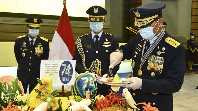 Kasau Marsekal TNI Yuyu Sutisna (kanan) memotong tumpeng usai memimpin upacara HUT ke-74 TNI AU di gedung Auditorium Denma Mabesau Cilangkap, Jakarta, Kamis (9/4). [Antara Foto]