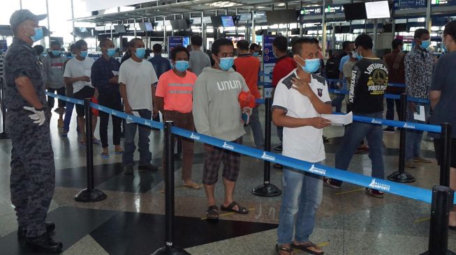 Tenaga Kerja Indonesia (TKI) ilegal dari berbagai tahanan Imigrasi di Semenanjung Malaysia berbaris di Bandara Kuala Lumpur International Airport (KLIA), Kamis (9/4).   [ANTARA Foto/Agus Setiawan]