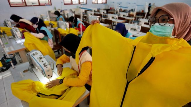 Siswa SMK menunjukan baju pelindung diri (Hazmat Suit) di SMKN 2 Blitar, Jawa Timur, Kamis (9/4).. [ANTARA FOTO/Irfan Anshori]