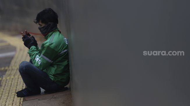 Pengendara ojek online menunggu pesanan di kawasan Pejaten, Jakarta, Jumat (10/4). [Suara.com/Angga Budhiyanto] 