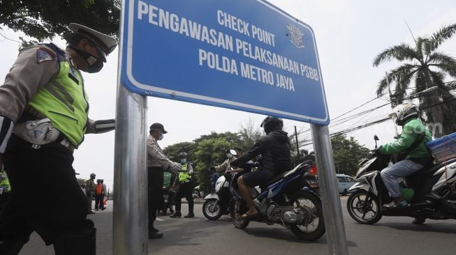 Polisi lalulintas beserta Dinas Perhubungan (Dishub) memeriksa pengendara sepeda motor saat melaksanakan pengawasan dalam penerapan Pembatasan Sosial Berskala Besar (PSBB) di jalan perbatasan Depok-Jakarta [Suara.com]. 