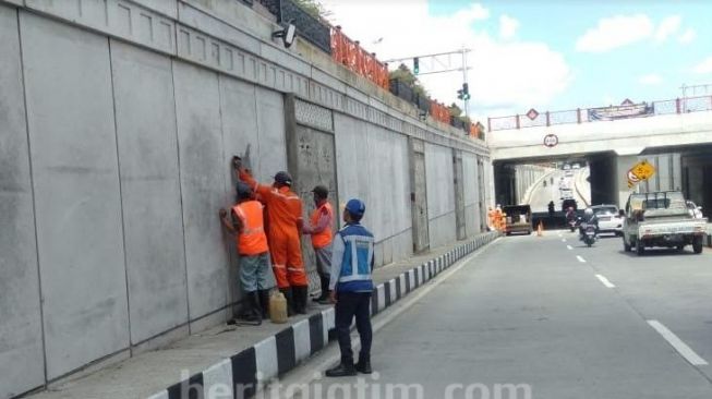 Dinding Underpass Karangploso di Kabupaten Malang, Jawa Timur, kembali dicorat-coret atau vandalisme yang dilakukan oknum tak bertanggung jawab. (Ist/Beritajatim)