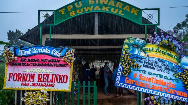 Sejumlah karangan bunga berisi protes kepada oknum warga penolak pemakaman jenazah di Tempat Pemakaman Umum (TPU) Siwarak Suwakul, Kelurahan Bandarjo, Ungaran Barat, Kabupaten Semarang, Jawa Tengah, Minggu (12/4). [ANTARA FOTO/Aji Styawan