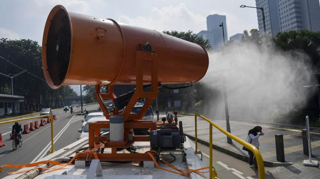 Petugas gabungan dari TNI dan Palang Merah Indonesia (PMI) melakukan penyemprotan cairan disinfektan dengan menggunakan mobil gunners spraying dikawasan Gatot Soebroto, Jakarta, Minggu (12/4).  [ANTARA FOTO/Nova Wahyudi]