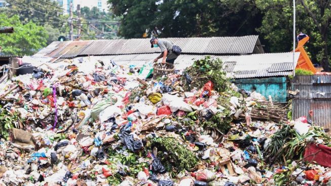 Petugas memilah sampah di TPS Kalibata, Jakarta Selatan, Senin (13/4). [Suara.com/Alfian Winanto]