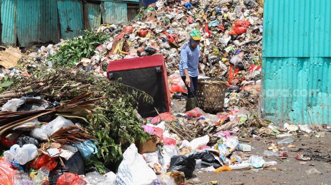 Pemulung mencari sampah di TPS Kalibata, Jakarta Selatan, Senin (13/4). [Suara.com/Alfian Winanto]