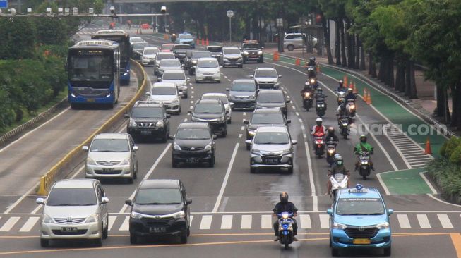 Kendaraan melintas di Jalan MH Thamrin, Jakarta, Senin (13/4). [Suara.com/Oke Atmaja]