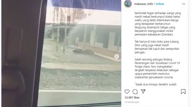 Petugas di Toraja menyemprotkan air ke masyarakat yang keluar tak pakai masker. (Instagram/makassar_iinfo)