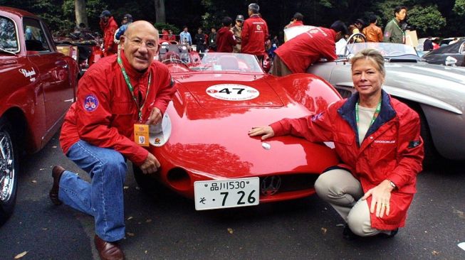 Legenda balap Formula One (F1) Britania Raya, Sir Stirling Moss (kiri) dan istrinya Susie Moss (kanan) berpose di samping Maserati 200 Si 1957 sebelum memulai festival reli mobil klasik, La Festa Mille Miglia 2001 di Tokyo. Beliau wafat dalam usia 90 tahun setelah lama sakit, demikian istrinya mengabarkan pada Minggu Paskah (12/4/2020) [AFP/Toshifumi Kitamura]. 