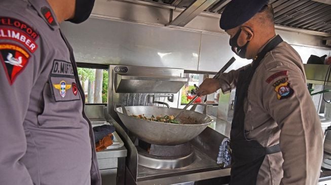 Anggota Polisi Polda Banten  memasak saat membuka dapur umum di Alun-alun Serang, Banten, Selasa (14/4).  [ANTARA FOTO/Asep Fathulrahman]