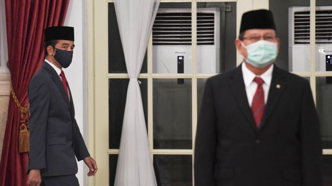 Presiden Joko Widodo memakai masker saat melantik Wakil Gubernur DKI Jakarta Ahmad Riza Patria di Istana Negara, Jakarta, Rabu (15/4). [ANTARA FOTO/Hafidz Mubarak]
