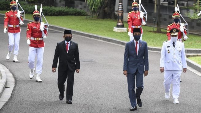 Presiden Joko Widodo memakai masker (tengah) berjalan bersama Wakil Gubernur DKI Jakarta Ahmad Riza Patria memakia masker (kanan) dan Mendagri Tito Karnavian memakai masker (kiri) sebelum pelantikan wakil gubernur DKI Jakarta di Istana Kepresidenan, Jakarta, Rabu (15/4). [ANTARA FOTO/Hafidz Mubarak]