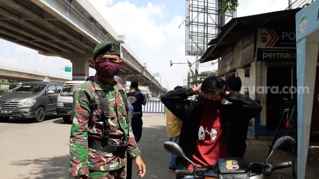 Petugas gabungan berikan masker kepada para pengendara motor yang lupa mengenakan saat bermotor di kawasan Kota Bekasi [Suara.com/Ummi Hadyah Saleh].