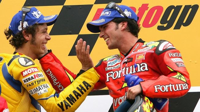 Toni Elias (kanan) merayakan keberhasilan menjuarai MotoGP Portugal di Sirkuit Estoril bersama Valentino Rossi yang finis kedua, Minggu (15/10/2006). [AFP/Nicolas Asfouri]