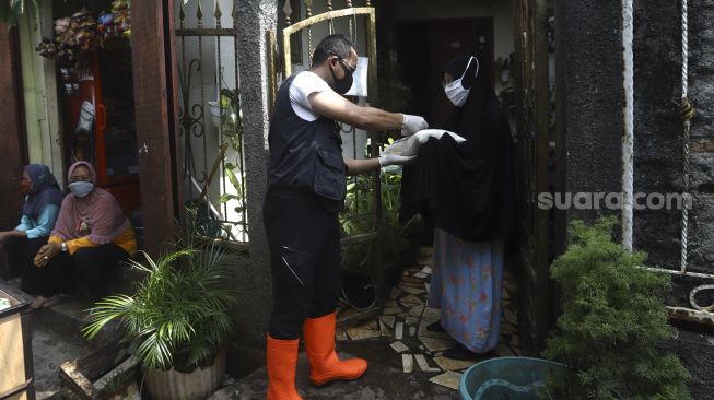 Waraga meneriman paket bahan pangan yang akan dibagikan kepada warga di kawasan Petamburan, Jakarta, Jumat (17/4). [Suara.com/Angga Budhiyanto]