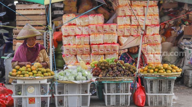 Pedagang buah menunggu pembeli di Pasar Minggu, Jakarta Selatan, Jumat (17/4). [Suara.com/Alfian Winanto]
