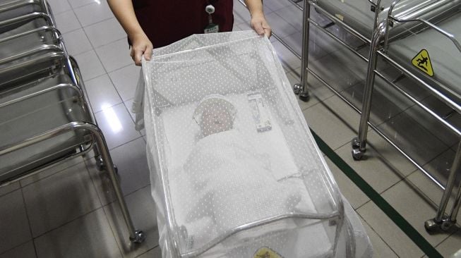 Perawat bersiap mengantarkan bayi yang memakai pelindung muka atau face shield kepada ibunya untuk disusui di RS Ibu dan Anak Asih, Jakarta, Jumat (17/4). [ ANTARA FOTO/Puspa Perwitasari]