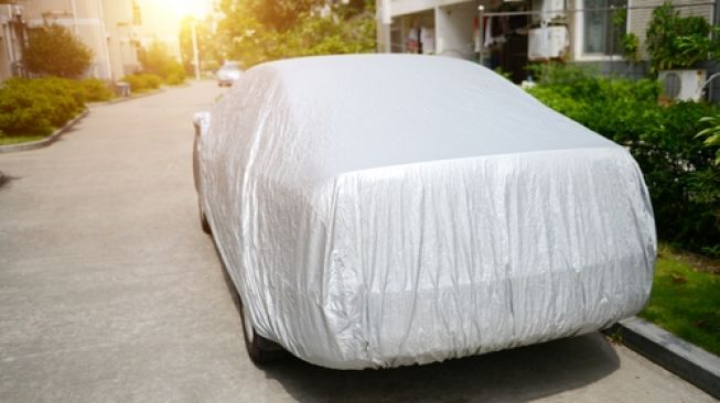 Cars cover atau selimut mobil untuk melindungi body dari perubahan cuaca dan kotor karena udara maupun zat polutan serta benda-benda sekelilingnya. Sebagai ilustrasi [Shutterstock].