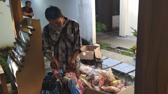 Kariyanto sedang menawarkan dagangannya berupa masker kain dan makanan ringan di salah satu gedung perkantoran di Wates, Kulon Progo, Sabtu (18/4/2020). - (SuaraJogja.id/Hiskia Andika)