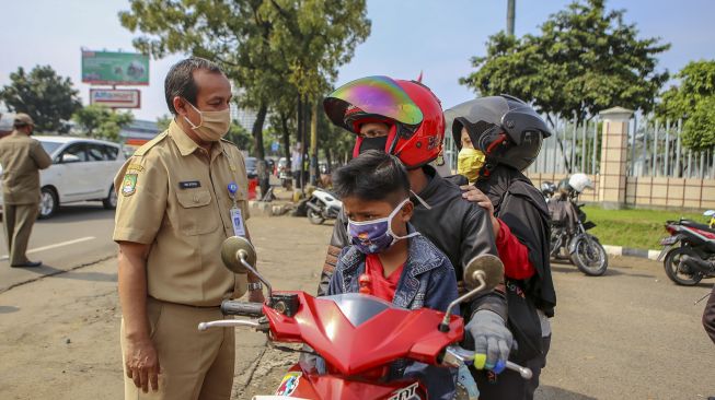 Petugas memeriksa pengendara saat penerapan Pembatasan Sosial Berskala Besar (PSBB) di jalan M.H Thamrin, Cikokol, Kota Tangerang, Banten, Sabtu (18/4). [ANTARA FOTO/Fauzan]