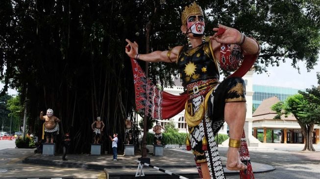 Patung wayang memakai masker kain di halaman Balai Kota Solo, Jawa Tengah, Minggu (19/4).  [ANTARA FOTO/Maulana Surya]