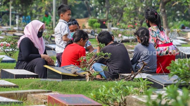 Warga melakukan ziarah kubur  di Tempat Pemakaman Umum (TPU) Karet Bivak, Jakarta Pusat, Minggu (19/4). [Suara.com/Alfian Winanto]