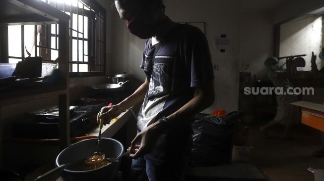 Relawan memasak di kafe milik sekelompok pemuda yang diubah menjadi dapur umum yang dinamai 'Dapur Untuk Rakyat' di kawasan Pisangan, Ciputat, Tangerang Selatan, Senin (20/4).  [Suara.com/Angga Budhiyanto